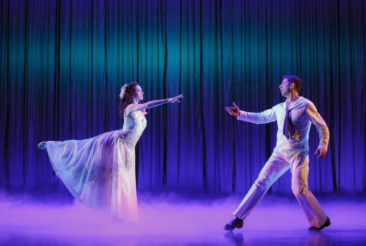 Two dancers approach each other on stage